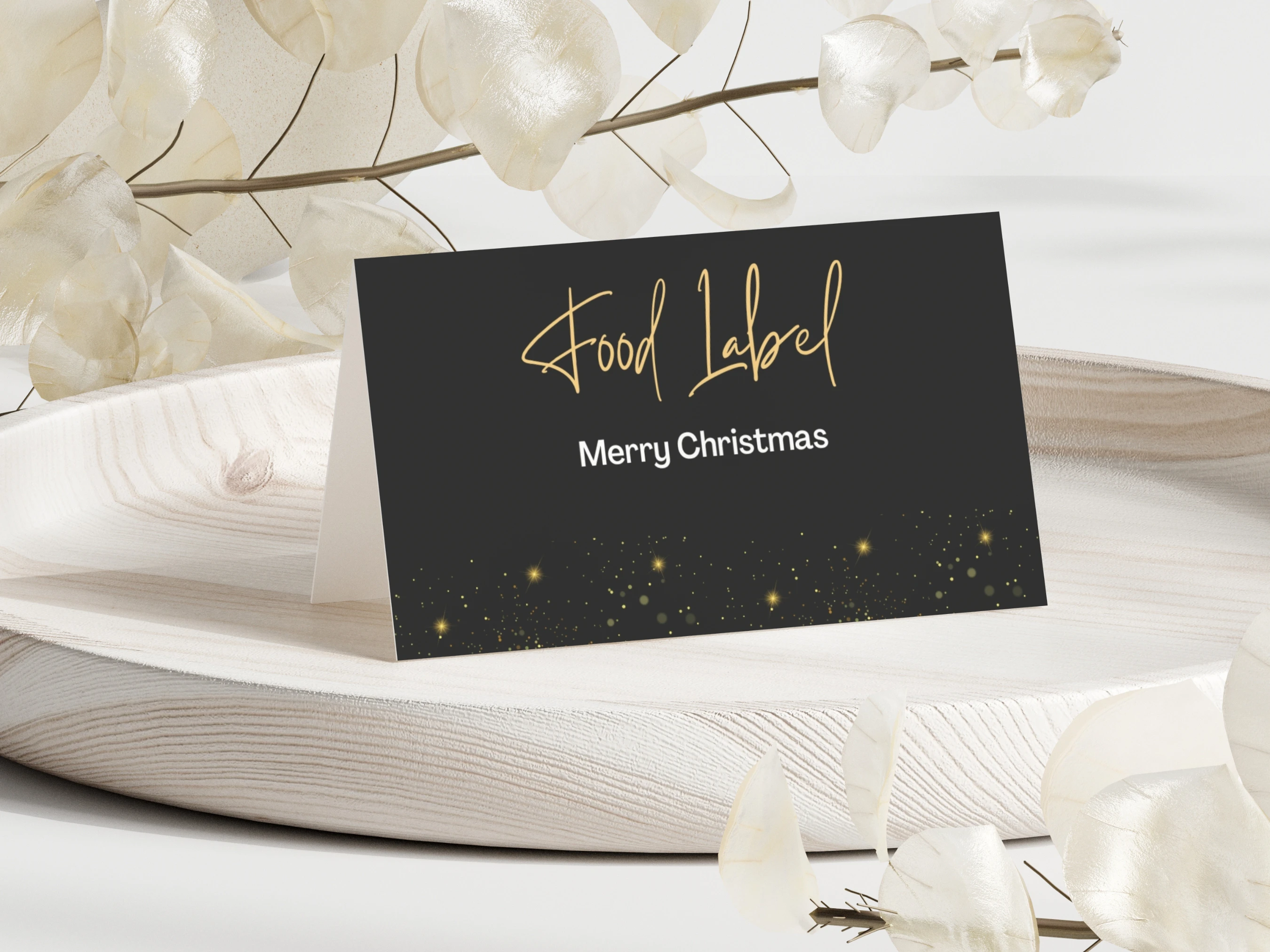 Black and Gold Christmas food tent card displayed on an elegant holiday table, featuring gold typography, festive sparkling accents and an editable Canva design for food labels or place cards.